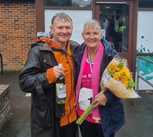 Wendy with husband Damian, holding flowers and wine