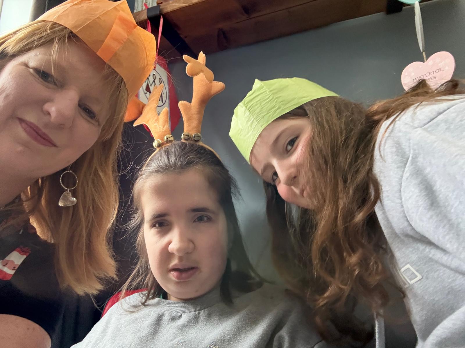Charlotte with her mum and sister in Christmas hats