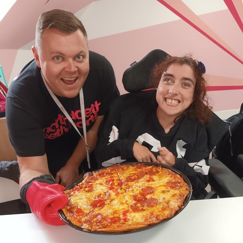 Support worker with service user making pizza